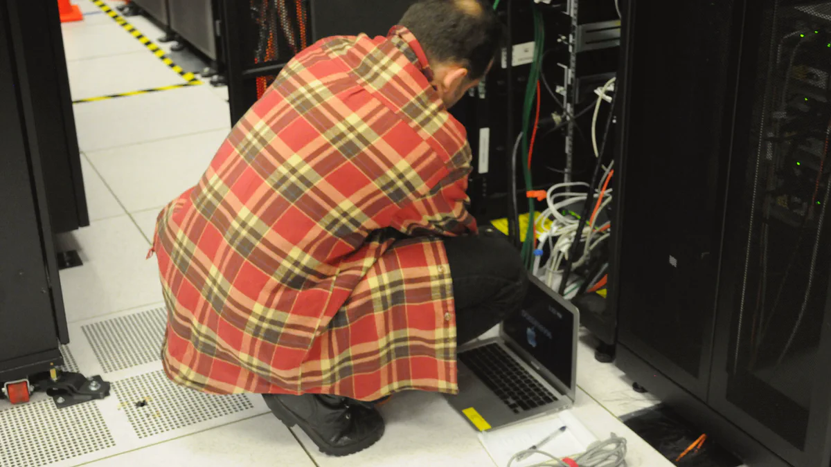 A technician working with a laptop in front of open server racks in a data center.