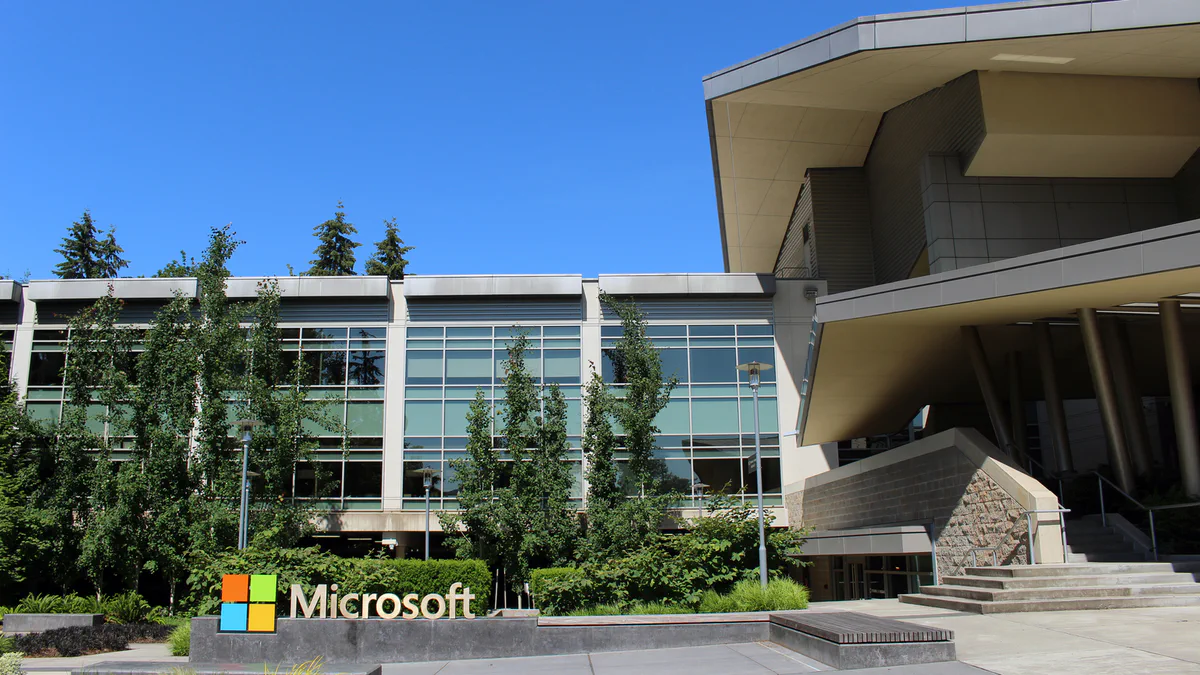 Glass facade of Building 92 at Microsoft's Redmond headquarters under a clear sky.
