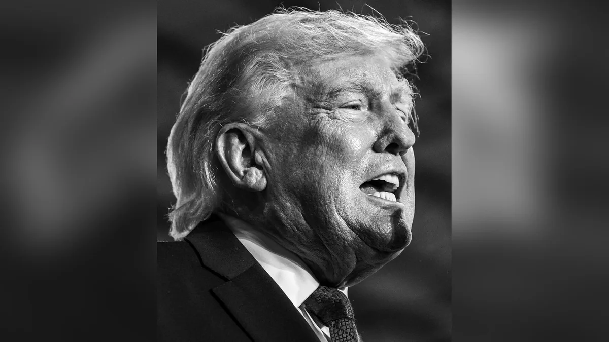President Donald Trump speaking at a podium during a March 2026 event, centered against a blurred background.