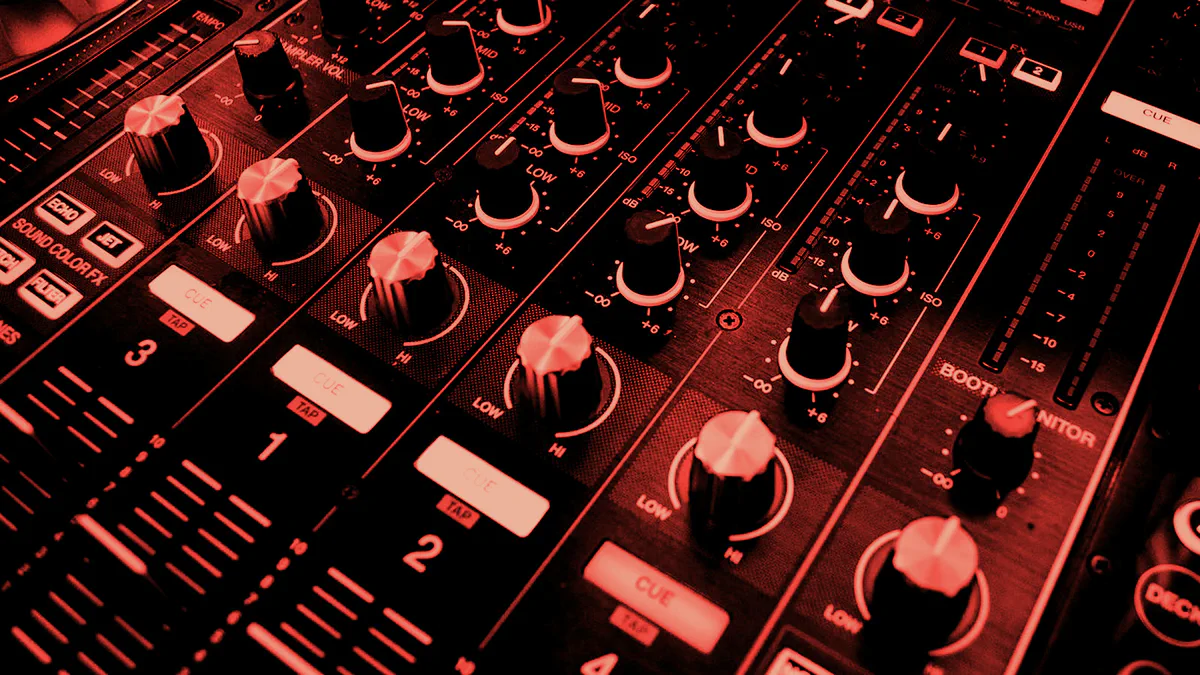 Red-toned close-up of an audio mixer showing decibel scales and level meters.